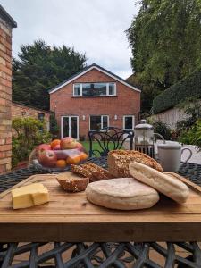 贝尔法斯特BT 9 Granny Flat & walled garden的一张木桌,上面有面包和其他食物