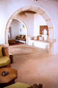 伊里德Dar Shams的客厅设有拱门、一张床和一张沙发