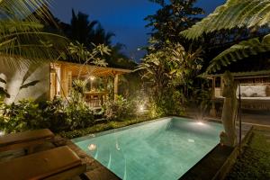 乌布Moringa Ubud Villa的夜间房子后院的游泳池