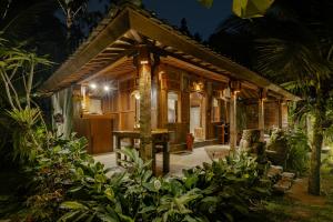 乌布Moringa Ubud Villa的夜晚在树林里的一个小屋