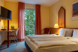 森登森登蒙塔纳酒店的配有一张床、一张书桌和一扇窗户的酒店客房