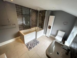 克鲁Two Bed Charming Cottage的带淋浴、浴缸和盥洗盆的浴室