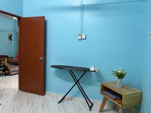 昔加末Segamat Tunas Homestay的一间设有桌子和蓝色墙壁的客房