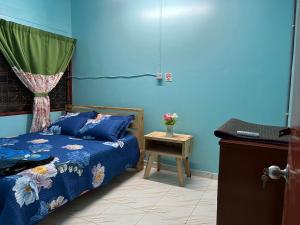 昔加末Segamat Tunas Homestay的蓝色卧室,配有床和桌子