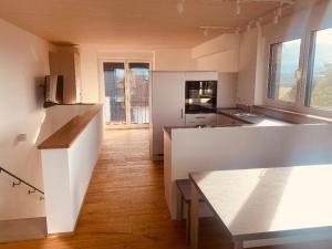 林道Obstbau Apartment am See的一间铺有木地板的大厨房,拥有白色的墙壁和木地板。