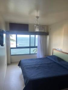 萨尔瓦多Ondina Apart Hotel - Apto 419的一间配备有蓝色床的卧室,享有海景