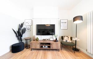 纽波特Urban Oasis by Keystone的客厅配有电视和桌椅