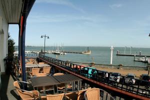 West CowesRoyal London Yacht Club的享有带椅子和桌子的码头的景色