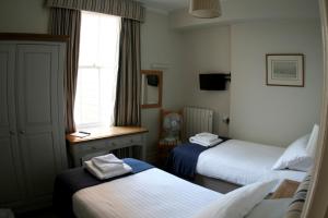 West CowesRoyal London Yacht Club的酒店客房设有两张床和窗户。