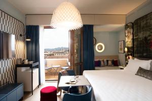 佛罗伦萨佛罗伦萨隆德拉酒店的酒店客房带一张床、一张桌子和椅子