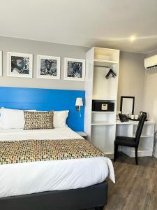 约翰内斯堡ONOMO Hotel Johannesburg Sandton的一间卧室配有一张床和一张桌子及椅子