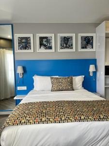 约翰内斯堡ONOMO Hotel Johannesburg Sandton的一间卧室设有蓝色的墙壁和一张大床