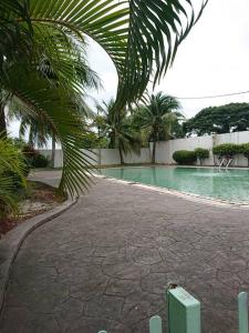 巴特沃思Butterworth homey House (3R2B + carpark)的旁边是一座棕榈树游泳池