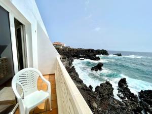 塔马达斯特Apartamento vista mar, a escasos metros de la playa的白色椅子,坐在一个海景阳台上