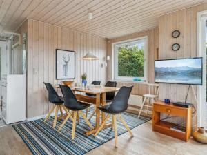 措斯泰兹Holiday Home Isabel - 500m from the sea in NW Jutland by Interhome的一间带木桌和椅子的用餐室