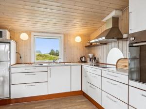 措斯泰兹Holiday Home Isabel - 500m from the sea in NW Jutland by Interhome的厨房配有白色橱柜和窗户。