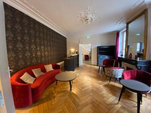蓬塔穆松Logis HOTEL DU PARC的客厅配有红色的沙发和2张桌子