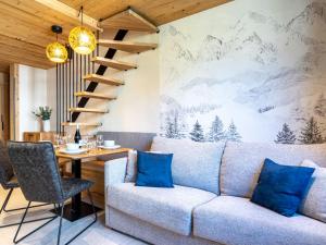 蒂涅Apartment Rond Point des Pistes - Val Claret-21 by Interhome的客厅配有沙发和带蓝色枕头的桌子