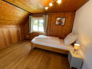艾森巴哈Holiday Home Landhaus Klara by Interhome的木制客房内的一间卧室,配有一张床