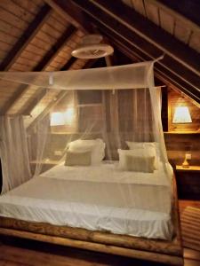 圣罗斯PURA VIDA Lodge Cabane perchée的卧室配有带枕头的白色天蓬床