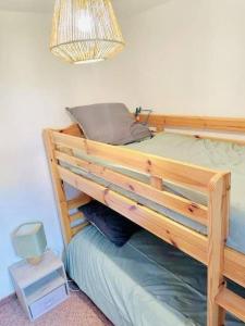 米茹Winter Cocon的卧室内的一张木制双层床,配有台灯