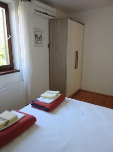 波拉特Villa Kučan的卧室配有白色的床和红色毯子