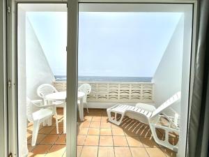 塔马达斯特Oceanfront apartment a few meters from the beach的阳台配有桌椅,享有海景。