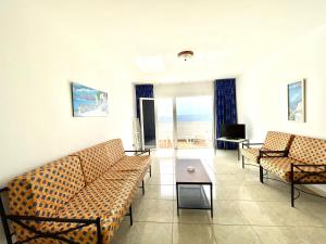 塔马达斯特Oceanfront apartment a few meters from the beach的带沙发的客厅,享有海景