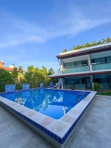 莫罗圣保罗Brisa do Mar Praia Hotel的房屋前的游泳池
