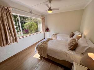温特顿Berg Escape Bottlebrush - Spacious Luxury Family Home的一间卧室设有两张床和窗户。