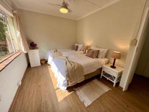 温特顿Berg Escape Bottlebrush - Spacious Luxury Family Home的一间卧室设有一张大床和一个窗户。