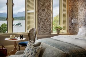 温德米尔兰代尔切斯酒店的一间卧室设有一张床,窗户设有水中的船只