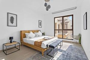 迪拜StoneTree - Elegant 1 BR in Madinat Jumeirah Living Rahaal 2的一间卧室配有一张床、一张桌子和一个窗户。