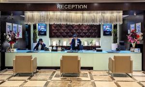 富查伊拉城市大厦酒店 的饭店的接待区,有两个人站在柜台