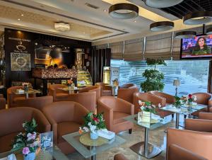 富查伊拉城市大厦酒店 的餐厅设有棕色的桌椅和电视。