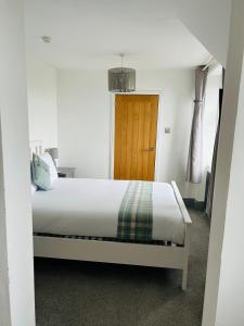 LochalineLochaline Hotel的一间卧室配有一张床和一扇木门