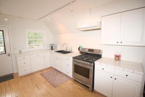 EntrikenMountain Getaway with Lake View的厨房配有白色橱柜和炉灶烤箱。