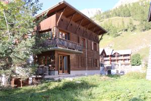 瓦勒迪泽尔Alpina Lodge Chalet By Valdiski的一座位于山丘上的大型木屋,设有阳台