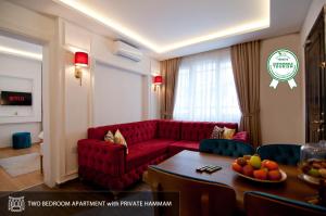 伊斯坦布尔Blue Mosque Suites 2 - Old City Sultanahmet的客厅配有红色的沙发和桌子