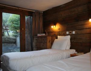 瓦勒迪泽尔Alpina Lodge Chalet By Valdiski的一间卧室设有两张床和窗户。