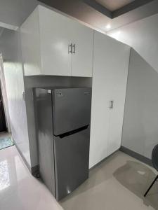 甲万那端Home in Cabanatuan city的小厨房配有白色橱柜和冰箱。