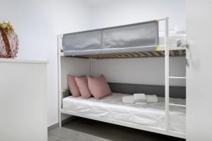 埃尔戈尔福Casa Marion的白色双层床,配有粉红色枕头