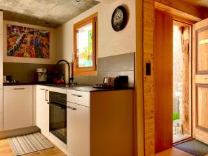 OscoLA CÀ NOVA. South Switzerland cozy gate away.的厨房配有白色橱柜和墙上的时钟