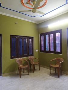 AyodhyaMalti Home stay 5 minute walking distance fromAyodhya DhamRailway Station的一间设有椅子和绿色墙壁及天花板的客房