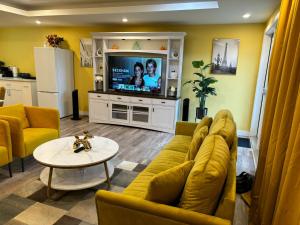 温尼伯Home away from home的客厅设有黄色沙发和电视