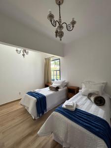 蒂拉登特斯Casa da Tuta Pousada的一间卧室配有两张床和吊灯。