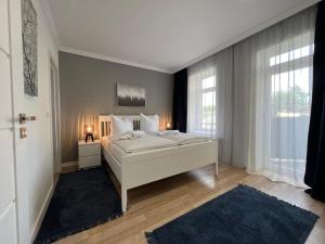 格拉130m² Designerwohnung mit 2 Vollbädern的卧室设有白色的床和大窗户