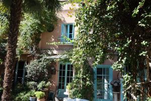 巴黎"Maison 1850 Paris 18" Chambre G avec terrasse et parking en option的粉红色的房子,拥有蓝色的窗户和树木