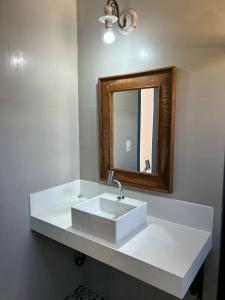 蒂拉登特斯Casa da Tuta Pousada的浴室设有白色水槽和镜子