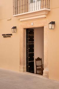 卡塞雷斯Casa Pizarro Hotel的通往带椅子和葡萄酒瓶的大楼的门